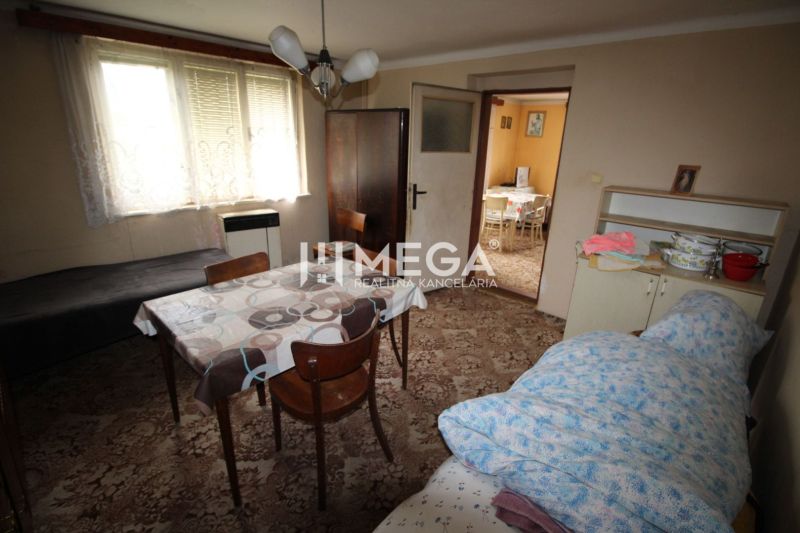 REZERVOVANÝ - Pôvodný rodinný dom v obci Dlhé nad Cirochou - Jedáleň v rodinnom dome s kobercovou podlahou, stolom a stoličkami.