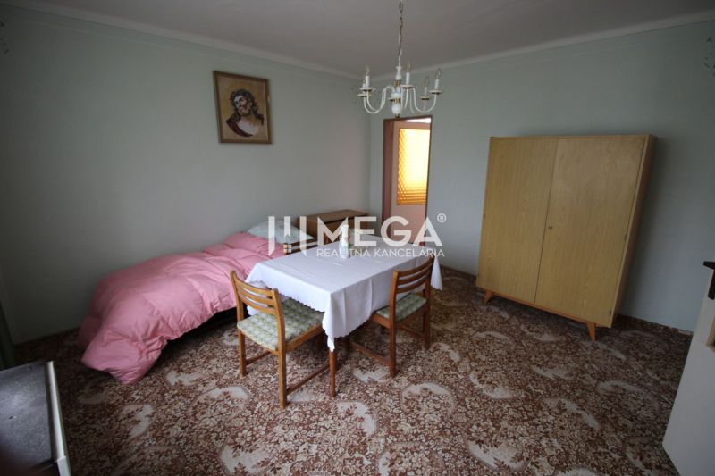 REZERVOVANÝ - Pôvodný rodinný dom v obci Dlhé nad Cirochou - Izba v rodinnom dome s jedálenským stolom, skriňou a obrazom na stene.