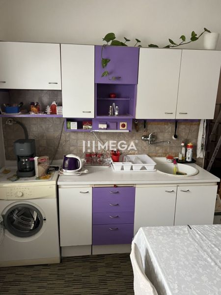 Znížena cena domu na Jesenského ulici v Snine - Kuchyňa v rodinnom dome s fialovými a bielymi skrinkami, kávovarom a umývačkou.