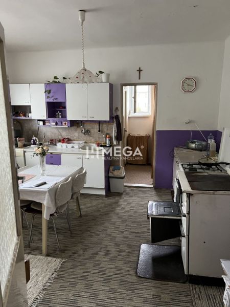 Znížena cena domu na Jesenského ulici v Snine - Kuchyňa v rodinnom dome s fialovými skrinkami a jedálenským stolom.