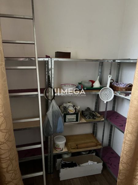 Znížena cena domu na Jesenského ulici v Snine - Regály s domácimi potrebami v rodinnom dome s podlahou s dreveným dekorom.