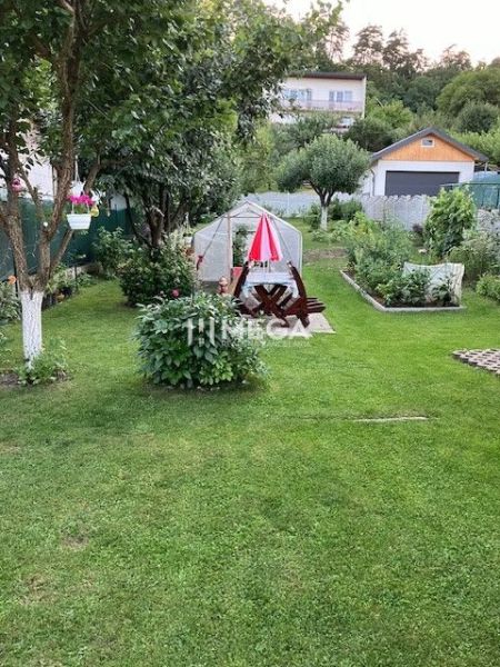 Znížena cena domu na Jesenského ulici v Snine - Záhrada rodinného domu na Jesenského ulici v Snine s altánkom a rastlinami.