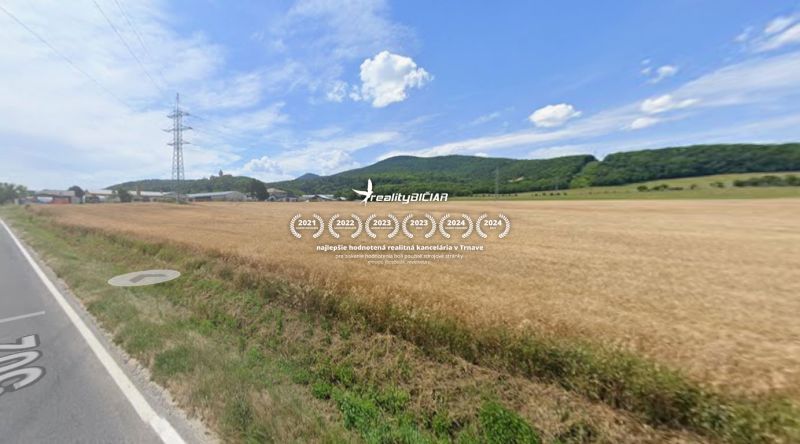 Investičná orná pôda 1 583 m² v Smoleniciach - Poľnohospodárske a lesné pozemky na Továrenskej ulici v Smoleniciach s výhľadom na kopce.