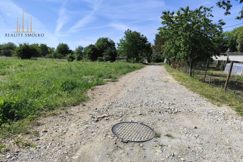 Na predaj pozemky vo Veľkom Šariši - Prírodné prostredie vo Veľkom Šariši, viditeľná štrková cesta a zeleň.