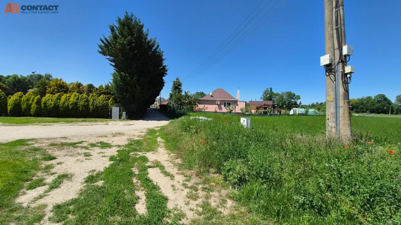 Stavebný pozemok v pokojnej časti obce Veselé - Pozemky na bývanie v meste Veselé na ulici Veselé s trávnatou plochou a domom.