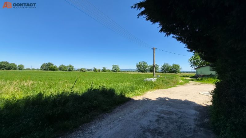 Stavebný pozemok v pokojnej časti obce Veselé - Zeleň a polia v Pozemkoch - bývanie na Veselé v obci Veselé pod modrou oblohou.