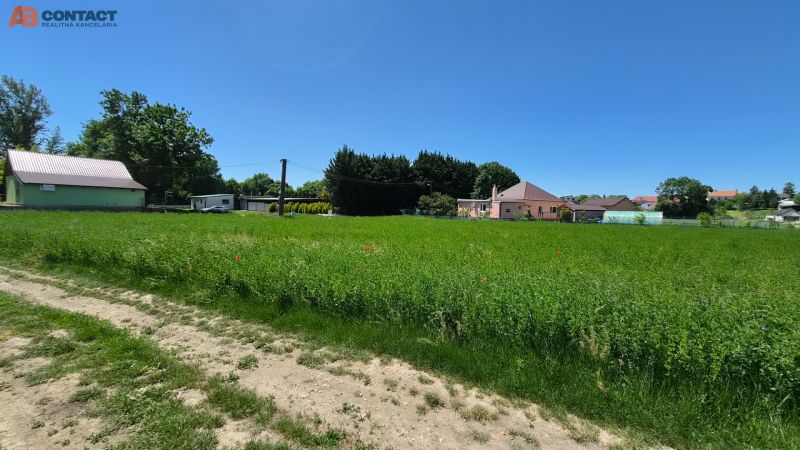 Stavebný pozemok v pokojnej časti obce Veselé - Trávnatý pozemok vo Veselom na Veselej, obklopený domami, vhodný pre bývanie.