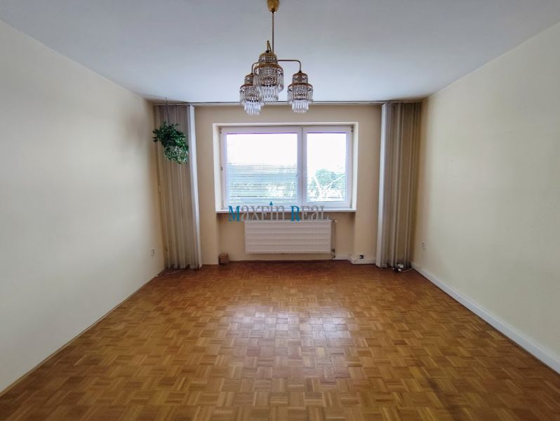 Na predaj priestranný 3-izbový byt s garážou v Nitre – Chrenová - Izba so zaveseným svetlom a podlahou s dreveným dekorom v 3-izbovom byte.