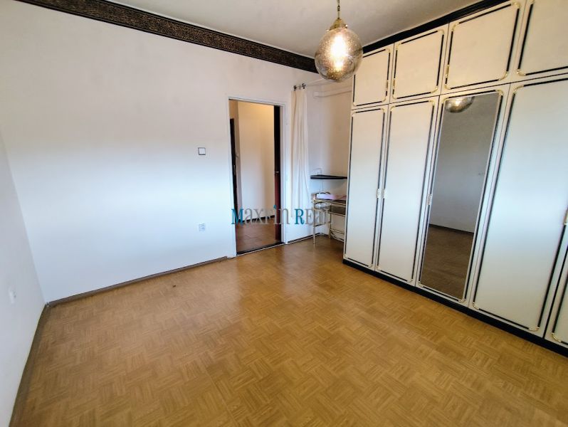 Na predaj priestranný 3-izbový byt s garážou v Nitre – Chrenová - Izba v 3-izbovom byte s veľkou skriňou, zrkadlom a podlahou s dreveným dekorom.