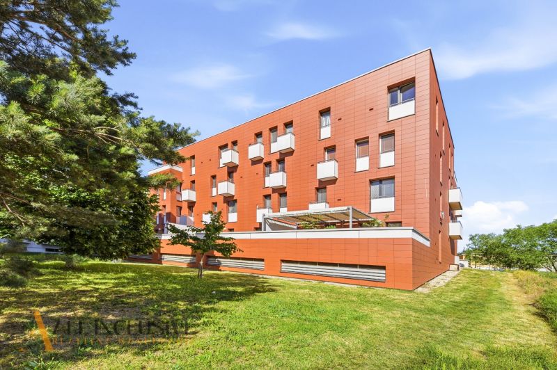 Na predaj 1-izb. s vlastným park. státím, Bratislava  - Budova s balkónmi a zeleňou v Bratislave - Záhorskej Bystrici, ideálna pre 1-izbový byt.