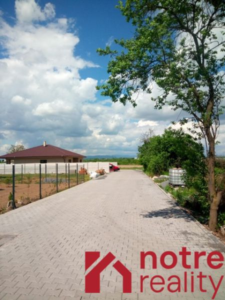 Stavebný pozemok v tichej lokalite mesta Lučenec - Spevnená cesta v Lučenci vedie k Pozemkom - bývanie, obklopená prírodou a domom.