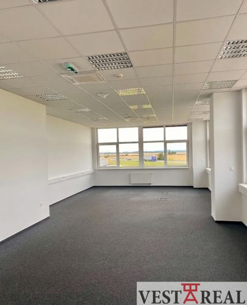 Prenájom A-Class logistickej haly s kanceláriami – 7 026 m², Galanta - Kancelárske priestory s kobercovou podlahou a veľkým oknom v budove skladov a hál.