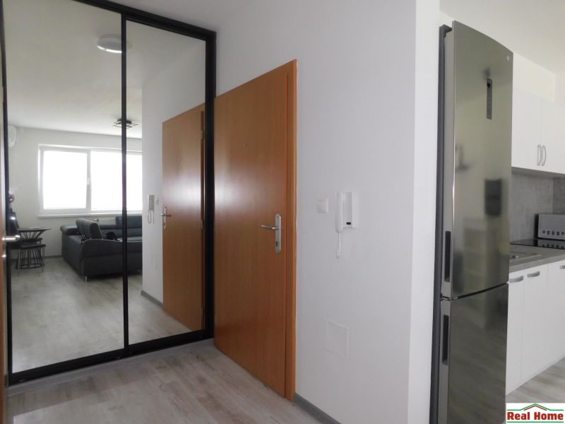 Moderný 2-izbový byt na prenájom-Hviezdoslavov–parkovanie,klimatizácia - Vstupná chodba s podlahou s dreveným dekorom, zrkadlovou skriňou a kuchynskou linkou v 2-izbovom byte.