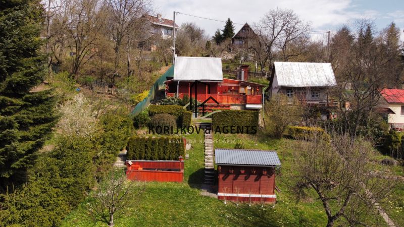 PREDAJ Rekreačná chata so záhradkou, Suchá Dolina, Košice-Sever - Chata na Kavečianskej ceste v Košiciach, mestská časť Sever, obklopená záhradou a stromami.