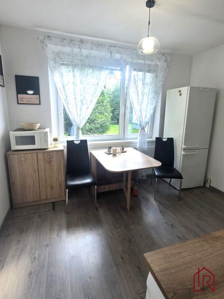 NA PRENÁJOM 1 izbový byt, Prešov, sídl. III, ul. Mukačevská - Kuchyňa v 1-izbovom byte s podlahou s dreveným dekorom, stôl, chladnička, mikrovlnná rúra.