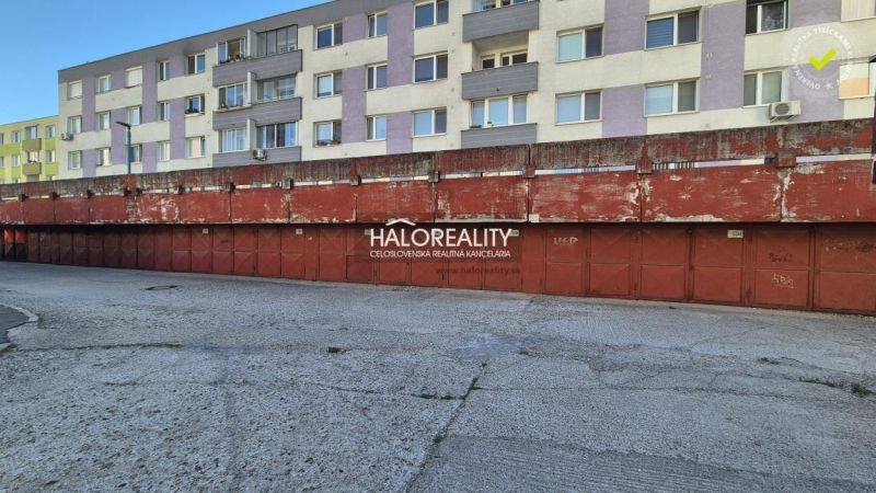 Predaj, garáž Bratislava Vrakuňa, Toryská - EXKLUZÍV... - Garáže v BA - Vrakuni pred obytnými budovami s vyblednutými červenými bránami.
