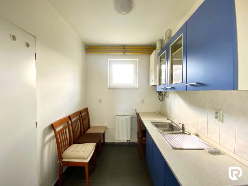 Obchodný priestor 75m2 | Zlatovská, Trenčín - Kuchynský priestor s modrými skrinkami a bielym obkladom, tri drevené stoličky.