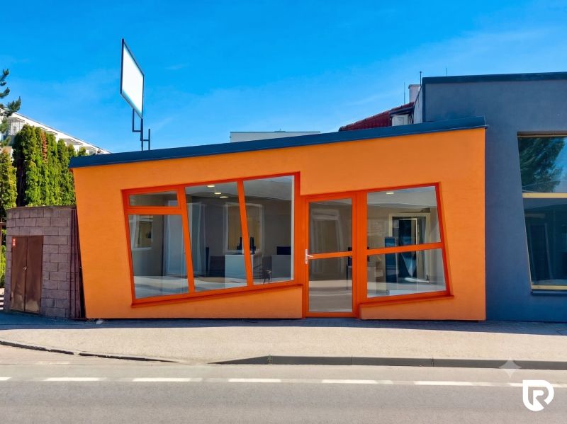 Obchodný priestor 75m2 | Zlatovská, Trenčín - Oranžová fasáda obchodných priestorov na Zlatovskej ulici v Trenčíne s veľkými sklenenými oknami.