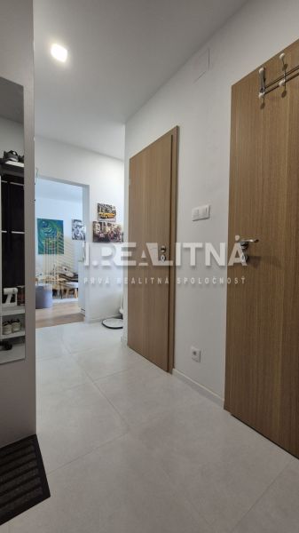 MODERNÝ DVOJIZBOVÝ BYT, 37M2, DÚBRAVKA - Chodba so vstupom do obývačky v 2-izbovom byte, svetlá dlažba a drevené dvere.