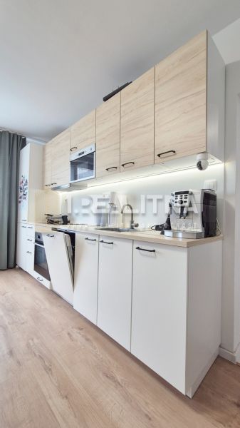 MODERNÝ DVOJIZBOVÝ BYT, 37M2, DÚBRAVKA - Kuchynská linka s dreveným dekorom v 2-izbovom byte, svetlá podlaha.