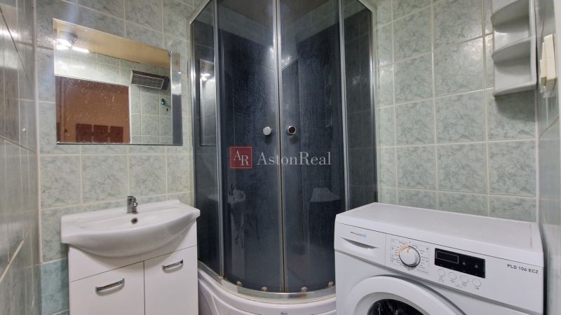 AstonReal: predaj 2-izbovy byt 57m2 + loggia, Kežmarok - K. Kuzmányho - Kúpeľňa s práčkou a sprchovým kútom v 2-izbovom byte, zelené obklady a zrkadlo.