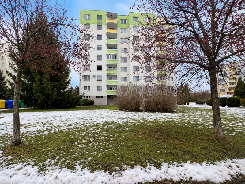Na predaj rovinatý pozemok pre parkovisko 778m2 -  Zvolen-Západ P098ZL - Panelák obklopený zeleňou a zasneženým trávnikom na Novozámockej ulici v Zvolene.