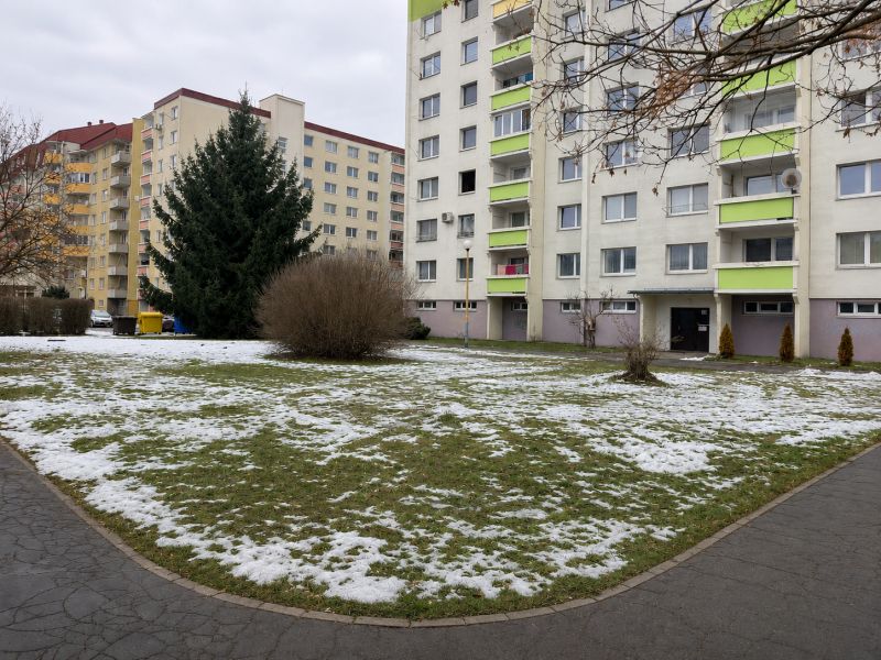 Na predaj rovinatý pozemok pre parkovisko 778m2 -  Zvolen-Západ P098ZL - Panelové domy obklopené zvyškami snehu na Novozámockej ulici, Zvolen, Banskobystrický kraj, Slovensko.