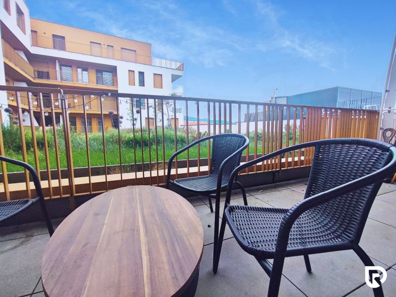 | Srdce Mesta | 2 Izb. byt | ORBIS |  70 m2 - Balkón s ratanovým sedením a výhľadom na architektúru Piaristickej ulice v Nitre.