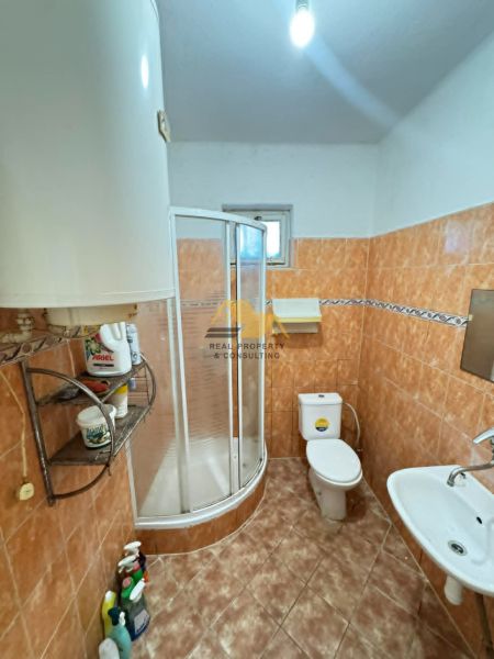 Exkluzívne! Predám 3 izbový rodinný dom v Komjaticiach - Kúpeľňa v rodinnom dome s oranžovým obkladom a sprchovým kútom.