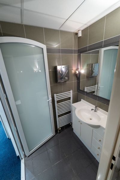 Meštiansky dom v centre Banskej Bystrice a parkovaním pre 24 áut D135Z - Kúpeľňa s umývadlom, zrkadlom, sprchovým kútom a rebríkovým radiátorom v budove.