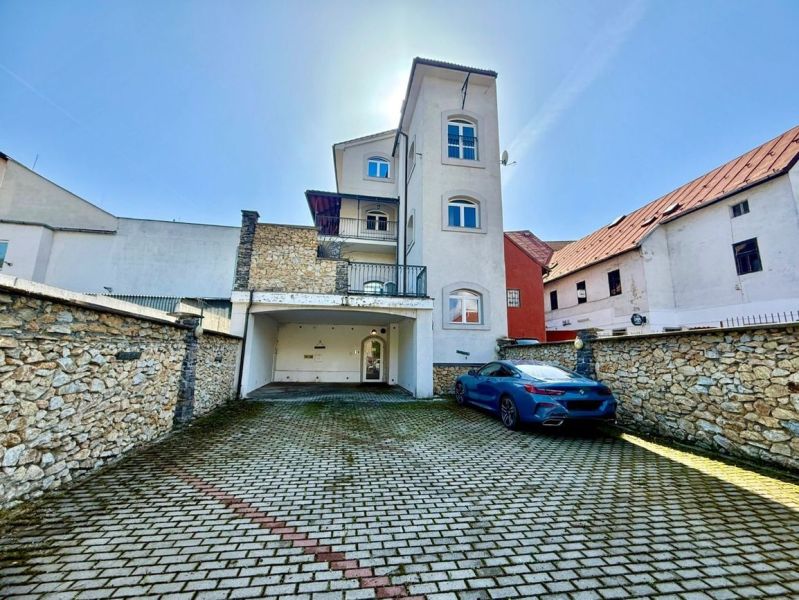 Meštiansky dom v centre Banskej Bystrice a parkovaním pre 24 áut D135Z - Budova na Dolnej ulici 28 v Banskej Bystrici s parkoviskom a kamenným múrom.