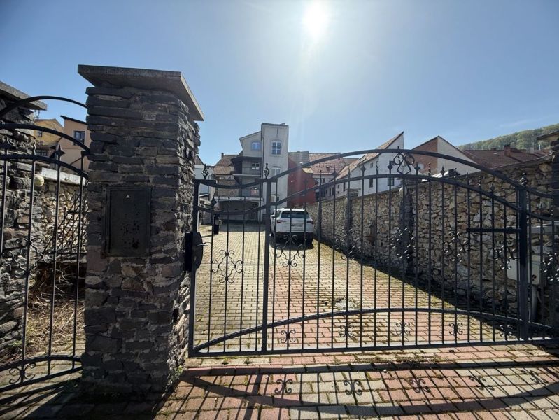 Meštiansky dom v centre Banskej Bystrice a parkovaním pre 24 áut D135Z - Zavretá kovová brána na ulici Dolná, Banská Bystrica, okres Banská Bystrica, Banskobystrický kraj, Slovensko.