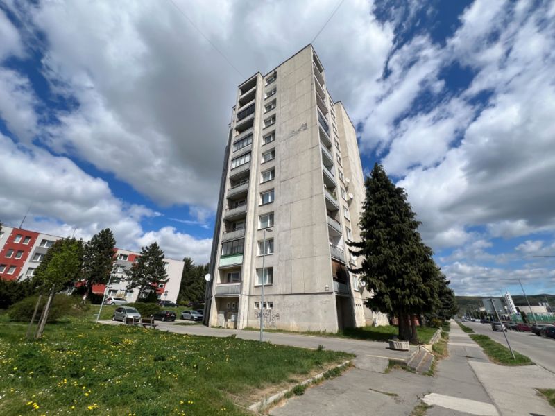 Na predaj 1-izbový byt s loggiou - Žiar nad Hronom, M. Chrasteka 1B718 - Panelák na ulici M. Chrásteka v Žiari nad Hronom, obloha je čiastočne zamračená.