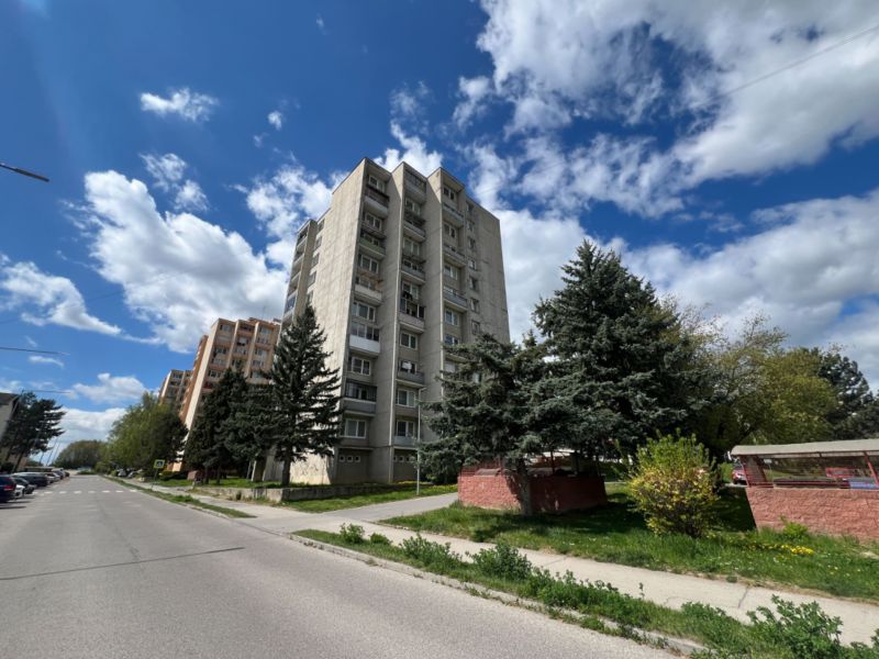 Na predaj 1-izbový byt s loggiou - Žiar nad Hronom, M. Chrasteka 1B718 - Bytové domy na M. Chrásteka, Žiar nad Hronom, obkolesené zeleňou a modrou oblohou.