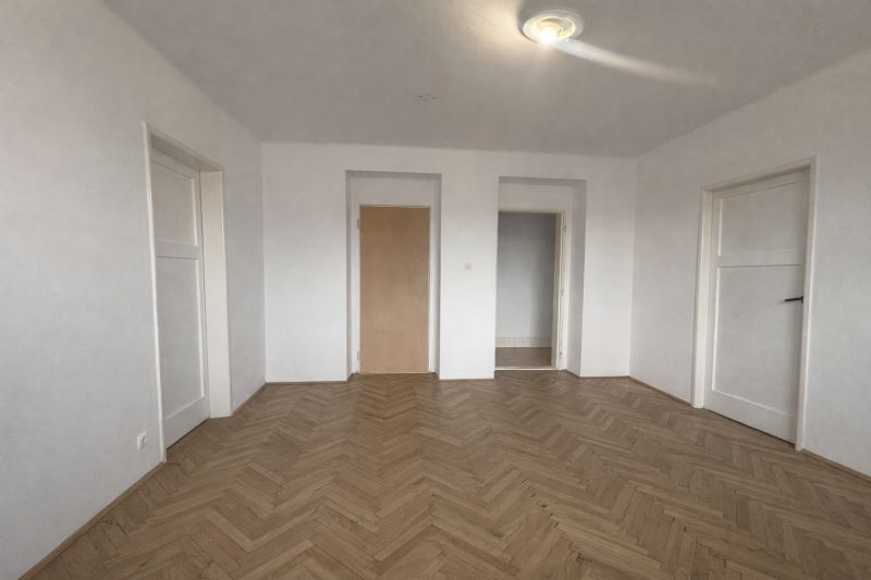 Na predaj 3-izbový byt s loggiou – Žiar nad Hronom, ul. D. Hrdinov - Interiér 2-izbového bytu s bielymi stenami a podlahou s dreveným dekorom.