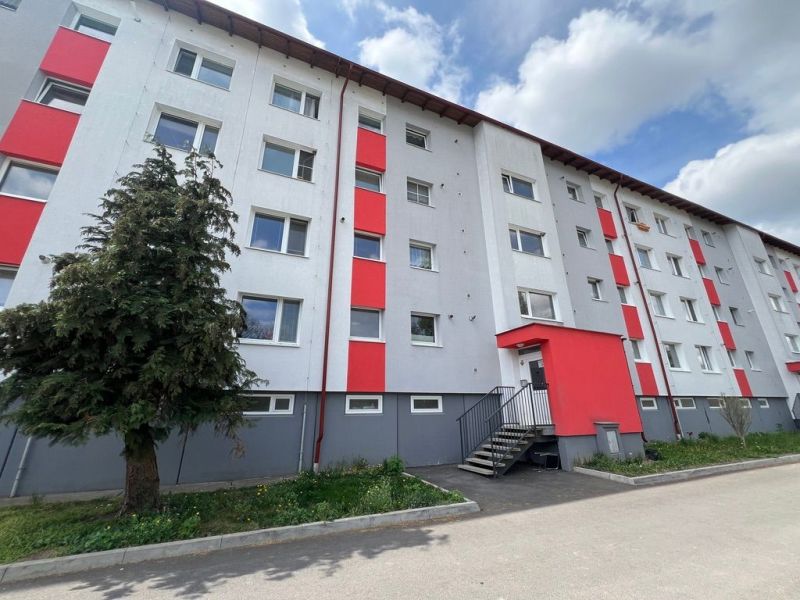 Na prenájom 2-izbový byt s veľkou loggiou v obci Slovenská Ľupča - Bytový dom na ulici Za Nožiarňou, Slovenská Ľupča, s výraznými červenými panelmi.