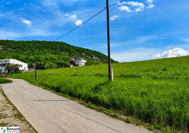 Priestranný stavebný pozemok 2 441 m² vo Finticiach - Kopcovitá krajina pri Finticiach s pozemkami na bývanie a vidiekom v pozadí.