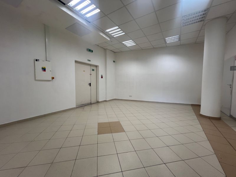 Obchodný priestor na prenájom 79 m² - Banská Bystrica NO718ZL - Prázdne obchodné priestory s dlaždicovou podlahou, biele steny, stropné osvetlenie.