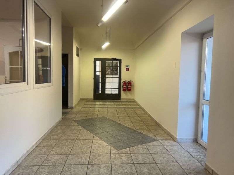 Prenájom skladové priestory s kanceláriami od 200 m² – Banská Bystrica - Chodba vo výrobných priestoroch s keramickou dlažbou a dvojkrídlovými dverami.