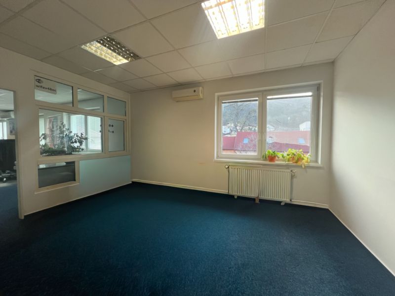 Prenájom skladové priestory s kanceláriami od 200 m² – Banská Bystrica - Kancelária s modrým kobercom a oknom, výrobné priestory.