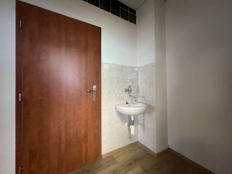 Prenájom kancelárske priestory 27 m² -Banská Bystrica, Zvolenská cesta - Kancelárie s umývadlom, dverami a podlahou s dreveným dekorom.