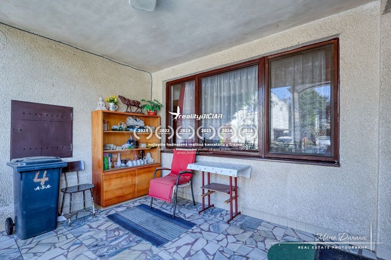6-izbový rodinný dom v obci Biely Kostol - V rodinnom dome je veranda so stoličkou, stolíkom, policami a dekoráciami.