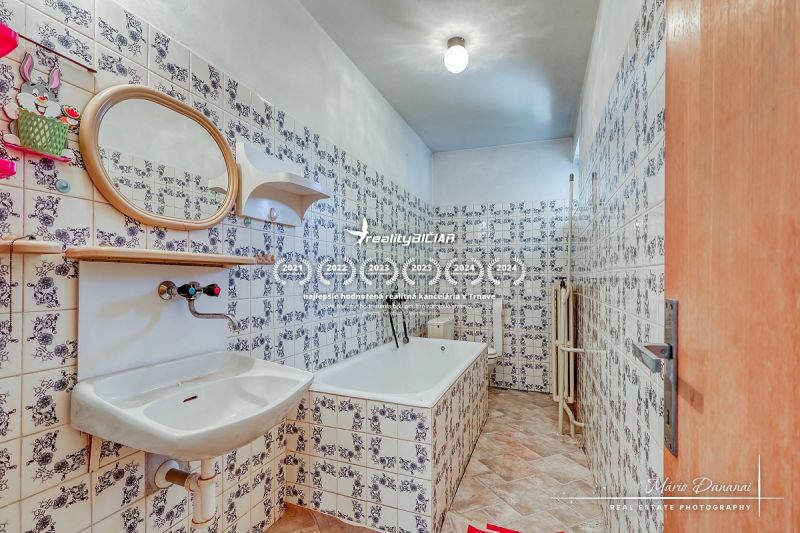 6-izbový rodinný dom v obci Biely Kostol - Kúpeľňa so vzorovanými obkladmi, umývadlom a vaňou v rodinnom dome.