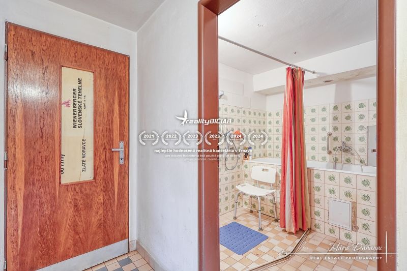6-izbový rodinný dom v obci Biely Kostol - Kúpeľňa v rodinnom dome s obkladom a sprchou so závesom.
