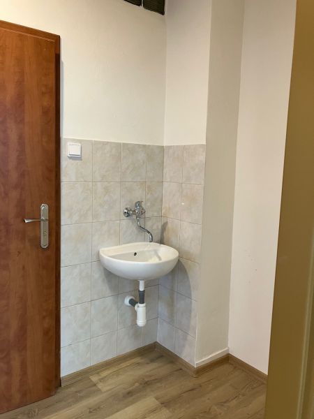 Na prenájom kancelárske priestory 66,6 m² - Banská Bystrica, Zvolenská - Malé umývadlo s kachličkami a podlahou s dreveným dekorom v Kancelárii.