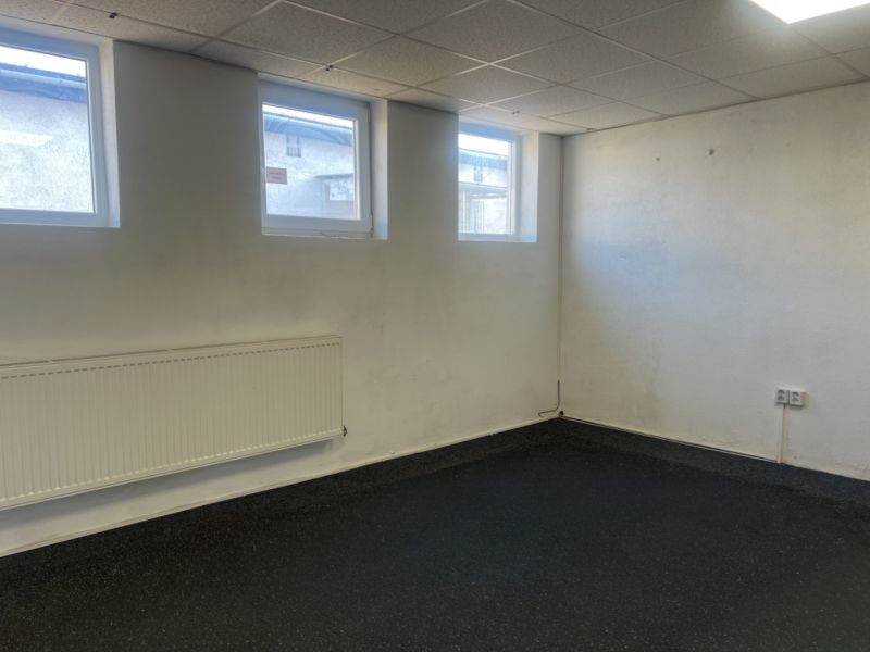 Skladové a výrobné priestori s kanceláriami 130 m² /180 m² /198 m² BB - Miestnosť s oknami, radiátorom a gumovou podlahou v sklade a halách.