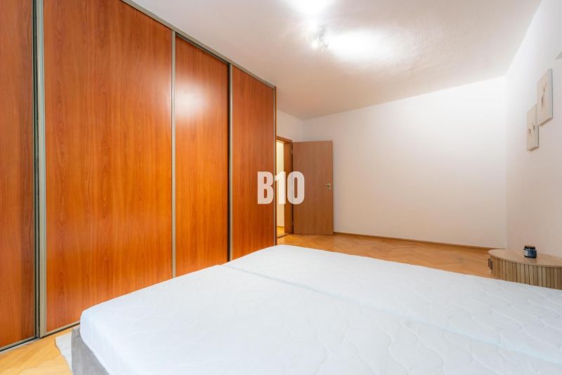 2 izbový kompletne zariadený byt Sever na prenájom - Spálňa s veľkou skriňou v 2-izbovom byte, podlaha s dreveným dekorom.