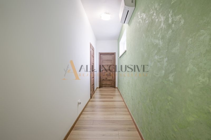 NA PREDAJ 4 IZBOVÝ RODINNÝ DOM - NOVOSTAVBA, ŠAMORÍN - Úzky chodník vedie k dverám, s klimatizáciou na stene a zelenou omietkou.