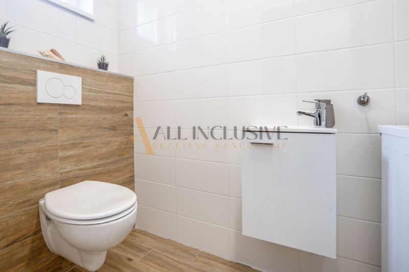 NA PREDAJ 4 IZBOVÝ RODINNÝ DOM - NOVOSTAVBA, ŠAMORÍN - Interiér kúpeľne s dreveným obkladom a elegantným vybavením v rodinnom dome.