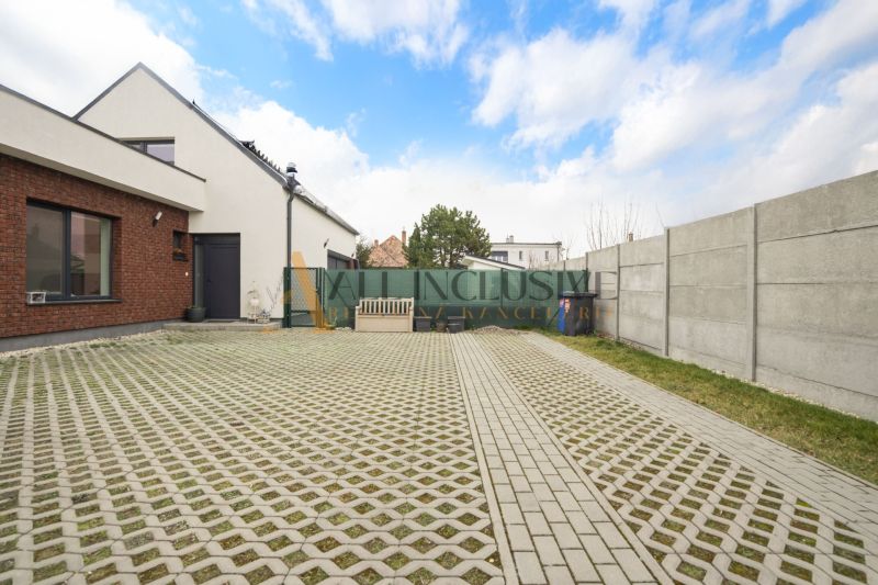 NA PREDAJ 4 IZBOVÝ RODINNÝ DOM - NOVOSTAVBA, ŠAMORÍN - Dvor rodinného domu s košom, lavičkou, plotom a modrou oblohou, popisuje nehnuteľnosť.